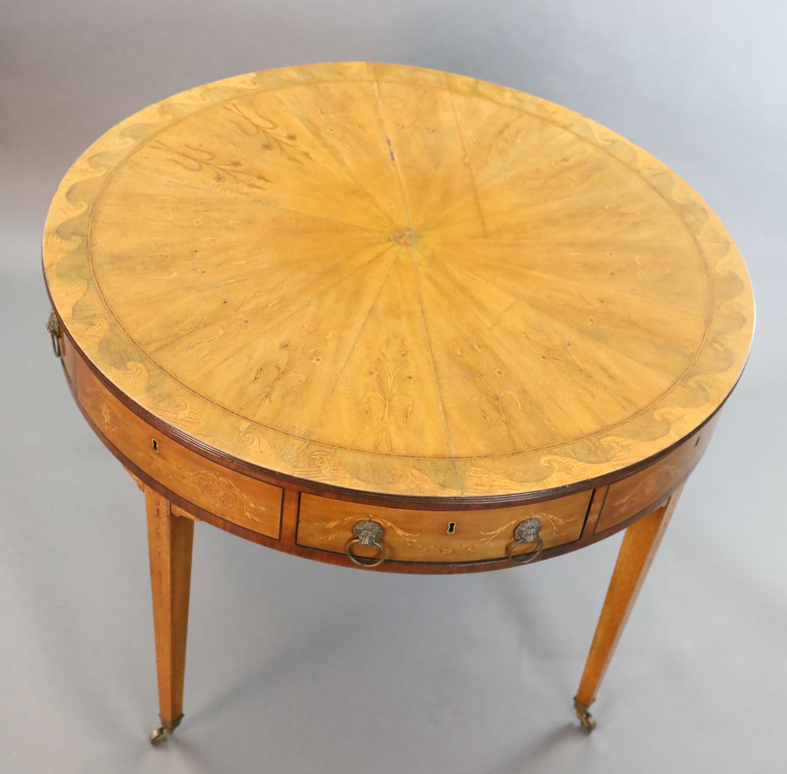 An Edwardian marquetry inlaid satinwood drum top library table, Diam. 3ft 5.5in H.2ft 5.5in.